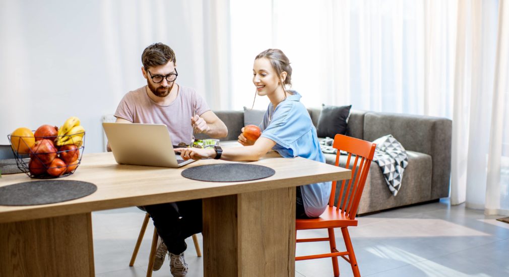 A perfect living room with a young couple with a sofa and curtains in the background